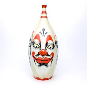 Bowling pin shaped clay vessel with a clown painted on it by tatoo artist