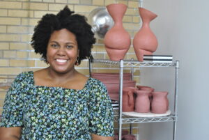 Kourtenay Plummer poses in front of her pottery in her private studio at the visual arts center of richmond